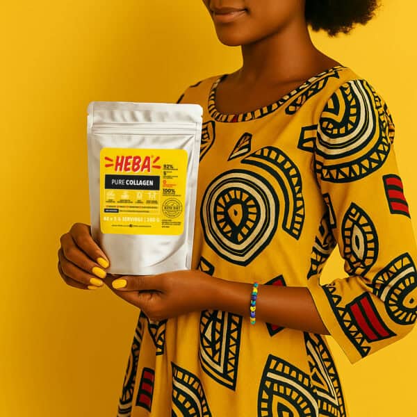 South African woman in a yellow patterned dress holding a pouch of HEBA Pure Collagen Powder, with yellow nails and a beaded bracelet, standing against a bright yellow background — highlighting clean protein support for skin, joints, and nails.